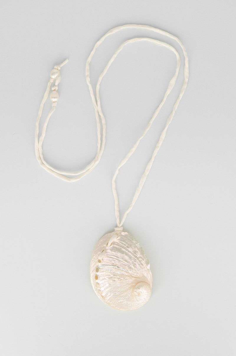 Necklace with a shell pendant on a light gray background
